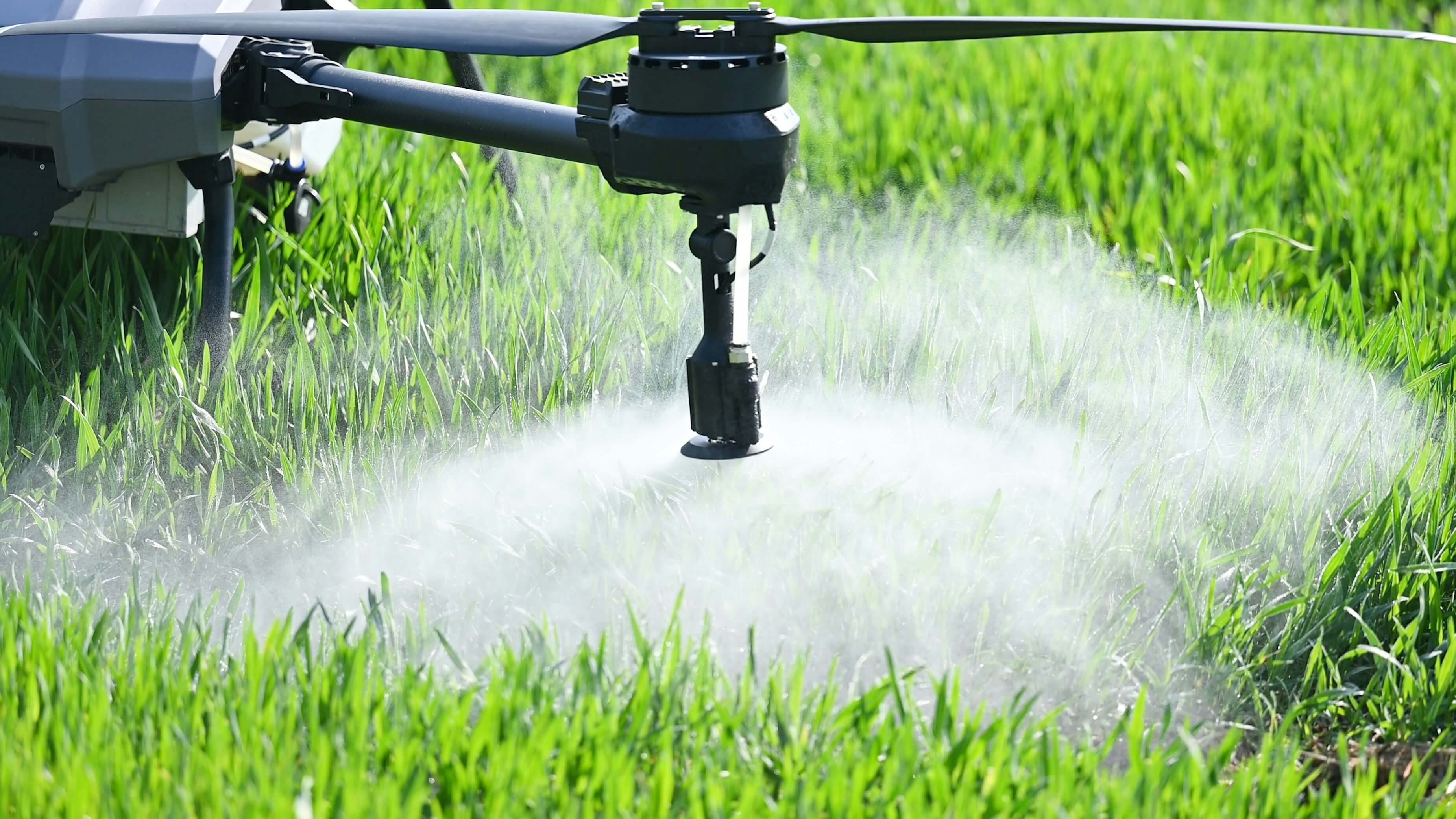 Dron pulverizador sobrevolando un campo de cultivo